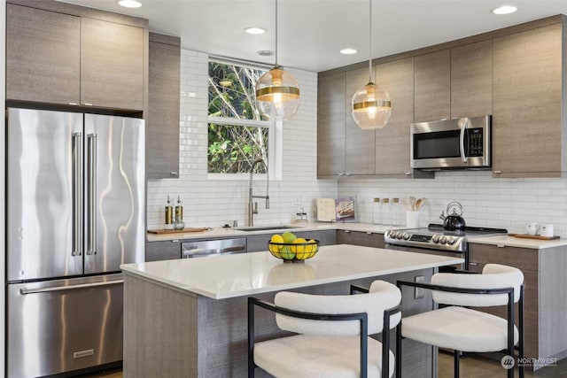 kitchen with a center island, appliances with stainless steel finishes, tasteful backsplash, hanging light fixtures, and a breakfast bar