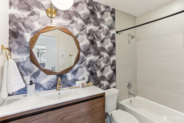 full bathroom with toilet, vanity, and tiled shower / bath