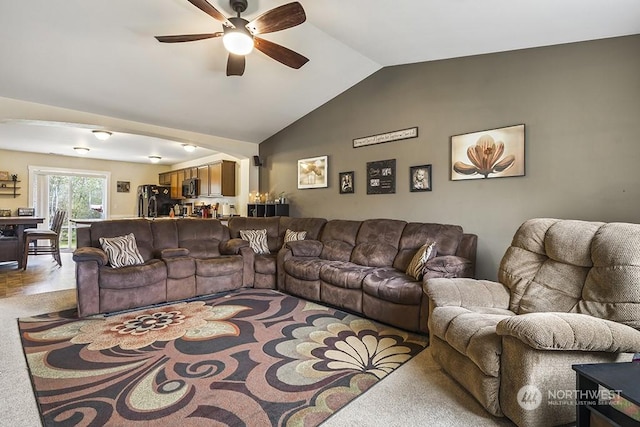 carpeted living room featuring vaulted ceiling and ceiling fan