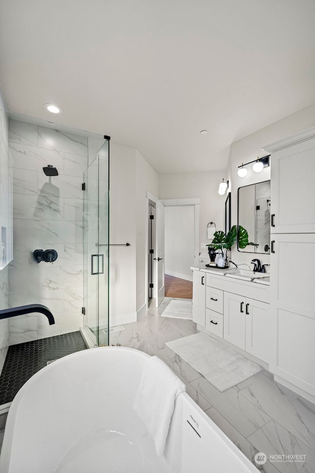 bathroom with vanity and shower with separate bathtub