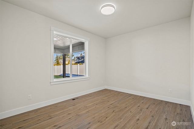 empty room with hardwood / wood-style flooring