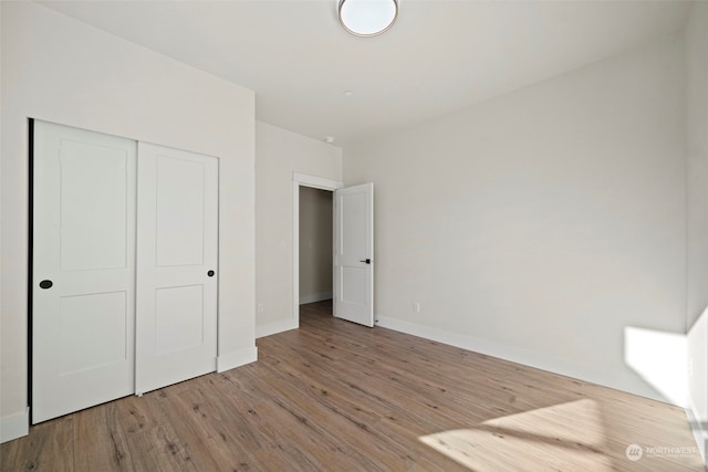 unfurnished bedroom featuring a closet and light hardwood / wood-style flooring