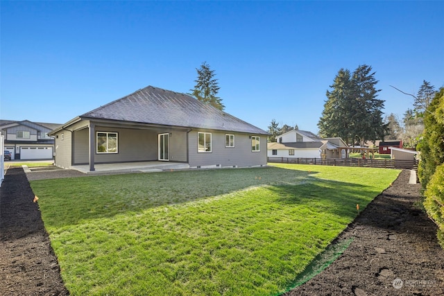 rear view of house with a patio and a lawn