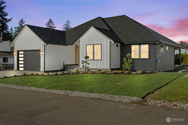 modern farmhouse with a garage and a lawn