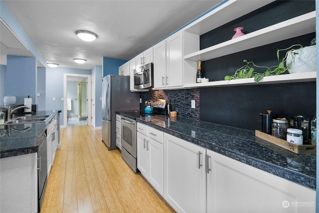 kitchen with sink, white cabinetry, stainless steel appliances, and tasteful backsplash