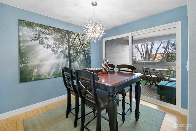 dining room featuring wood-type flooring and an inviting chandelier