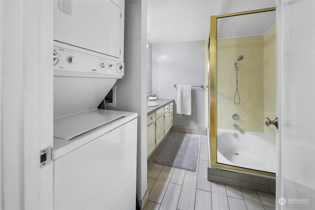 washroom featuring stacked washer and dryer and wood tiled floor