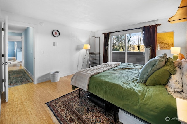 bedroom with access to exterior and light hardwood / wood-style flooring