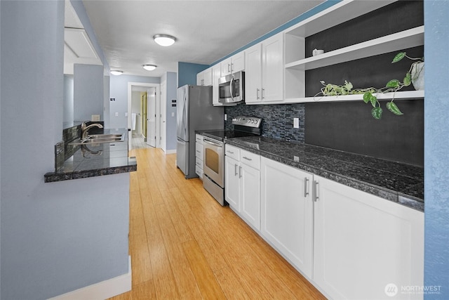 kitchen featuring white cabinets, light wood-style flooring, appliances with stainless steel finishes, open shelves, and a sink