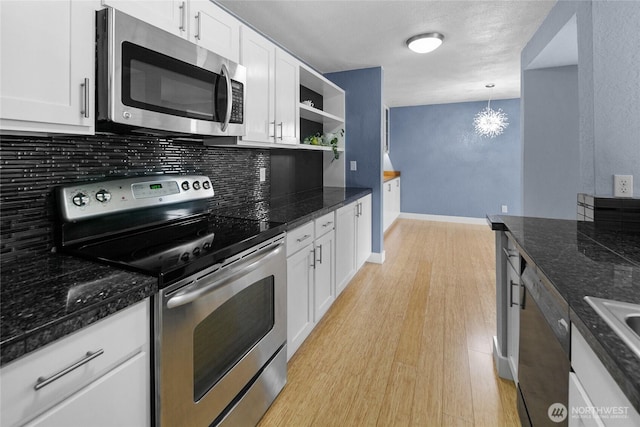 kitchen with light wood-style flooring, stainless steel appliances, white cabinetry, open shelves, and pendant lighting