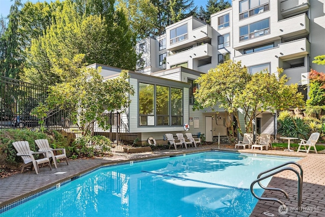 pool with a patio area and fence