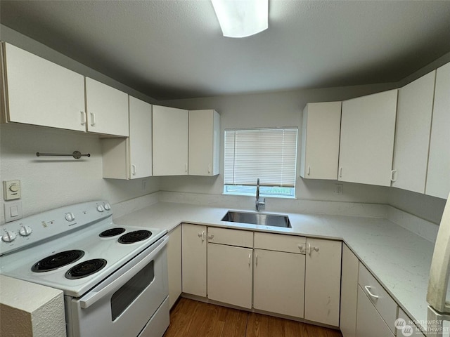 kitchen featuring sink, white electric range, and white cabinets