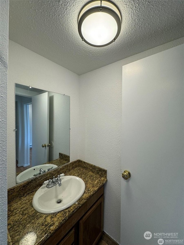 bathroom with vanity and a textured ceiling