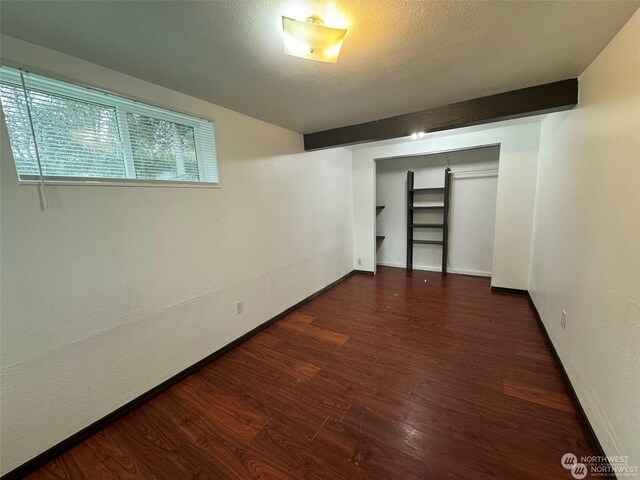 basement featuring dark wood-type flooring and a textured ceiling