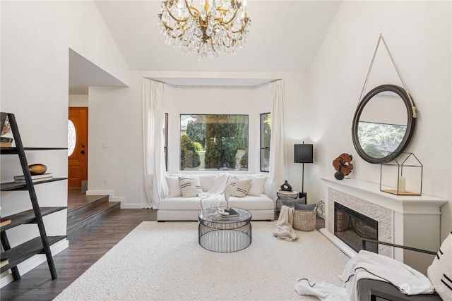 living room with dark wood-type flooring, a chandelier, and vaulted ceiling