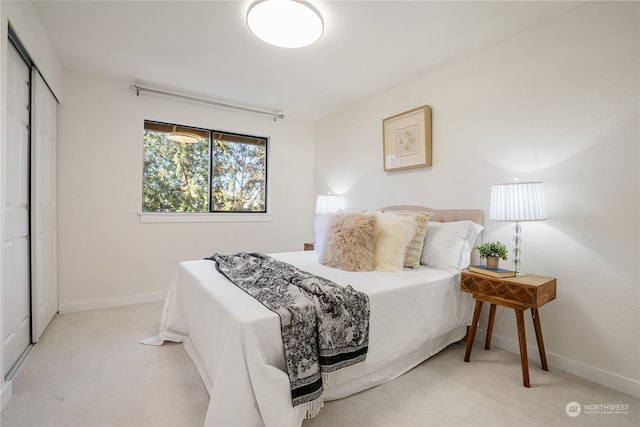 bedroom with a closet and light carpet