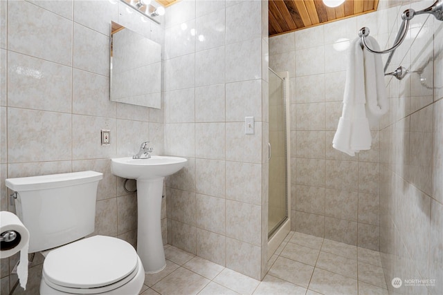 bathroom featuring tile patterned floors, tile walls, wood ceiling, toilet, and a shower with shower door