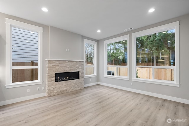 unfurnished living room featuring a fireplace and light hardwood / wood-style flooring