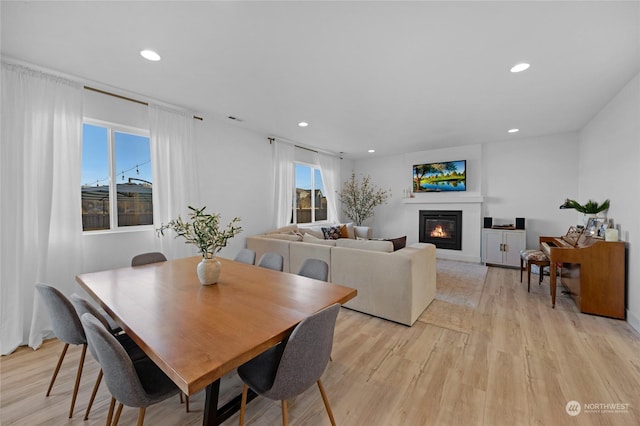 dining space with light wood-type flooring and a healthy amount of sunlight