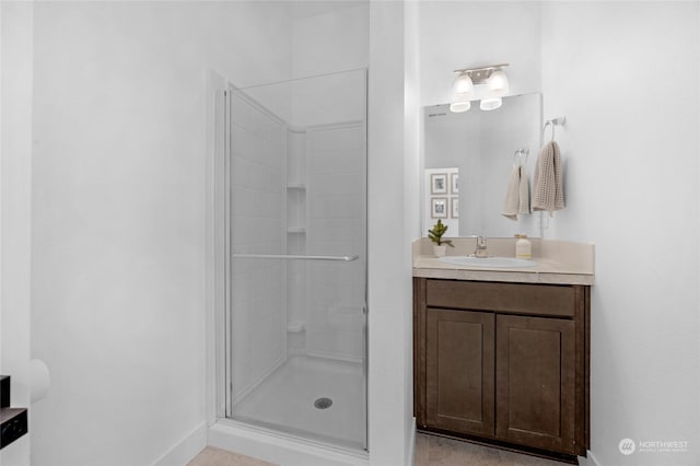 bathroom with a shower with shower door and vanity