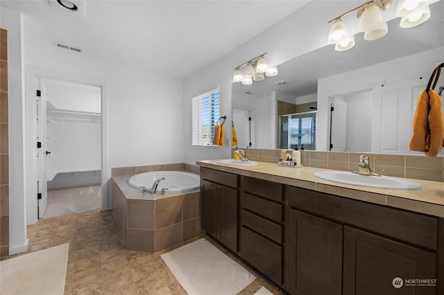 bathroom featuring backsplash, vanity, and separate shower and tub