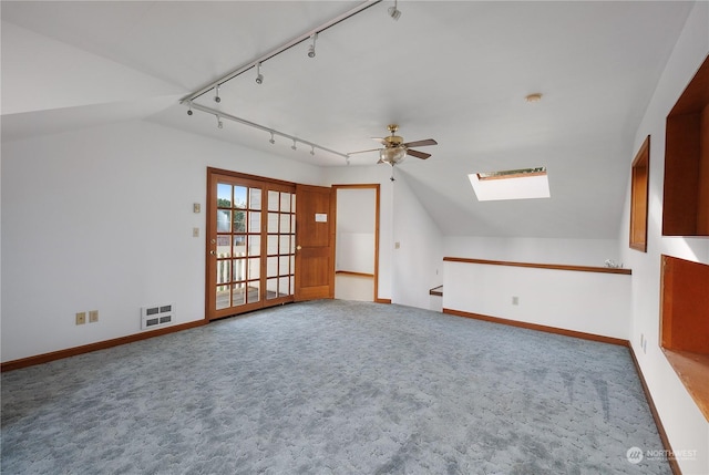 bonus room featuring carpet flooring, vaulted ceiling with skylight, heating unit, and ceiling fan