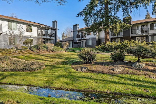 view of property's community featuring a yard and a water view