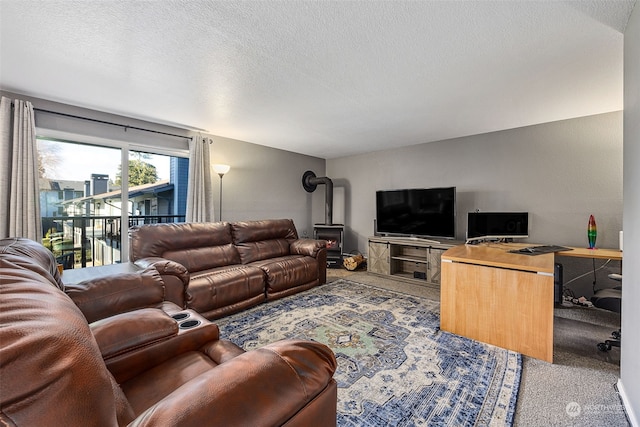 carpeted living room featuring a textured ceiling and a wood stove