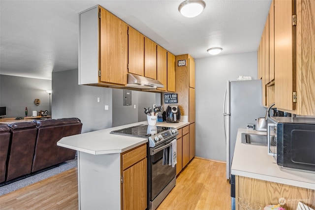 kitchen featuring appliances with stainless steel finishes, kitchen peninsula, and light hardwood / wood-style flooring