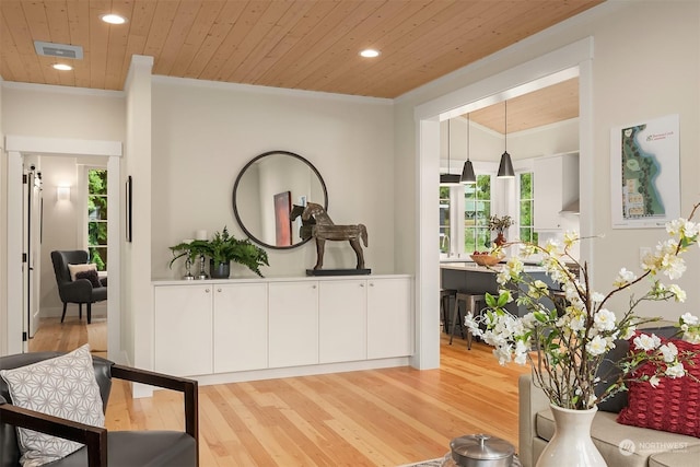 hallway with plenty of natural light, crown molding, light hardwood / wood-style floors, and wooden ceiling