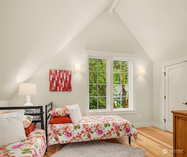 bedroom featuring hardwood / wood-style floors and lofted ceiling with beams