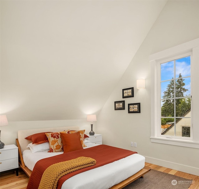 bedroom featuring hardwood / wood-style floors and lofted ceiling