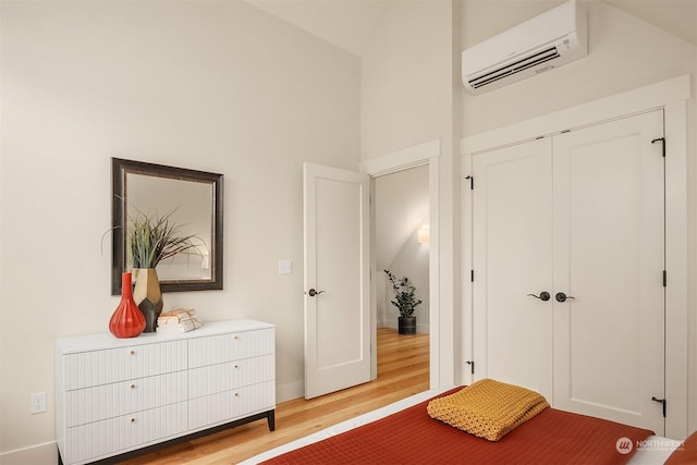 bedroom featuring a closet, an AC wall unit, and light hardwood / wood-style floors