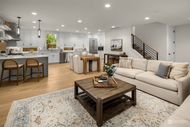 living room with light wood-type flooring and sink