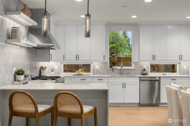 kitchen with sink, white cabinetry, light stone countertops, and appliances with stainless steel finishes