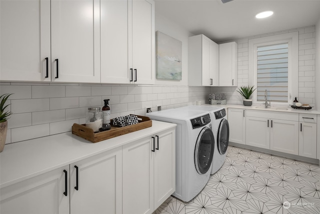 washroom with cabinets, sink, separate washer and dryer, and light tile patterned flooring