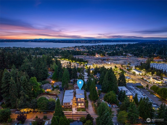 aerial view at dusk featuring a water view