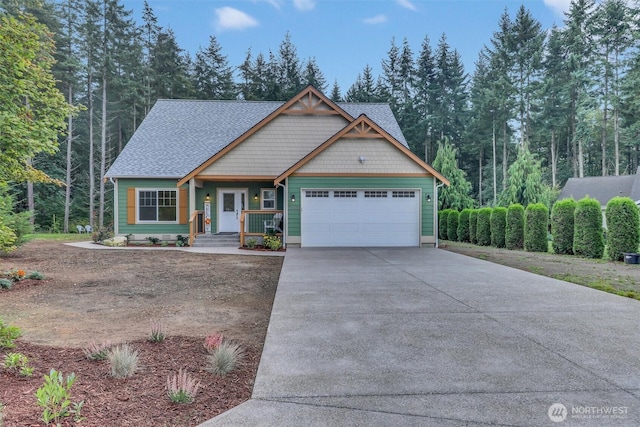 craftsman-style house with a garage, concrete driveway, and a shingled roof