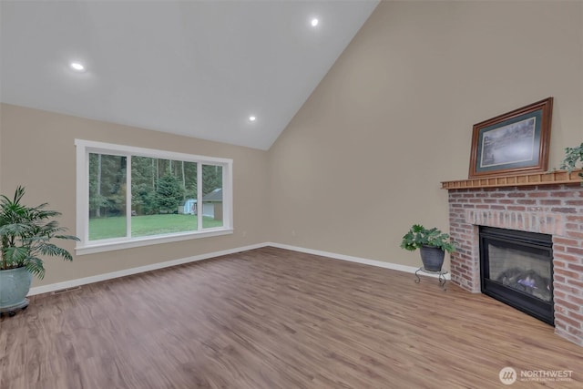 unfurnished living room with baseboards, a brick fireplace, visible vents, and light wood-style floors