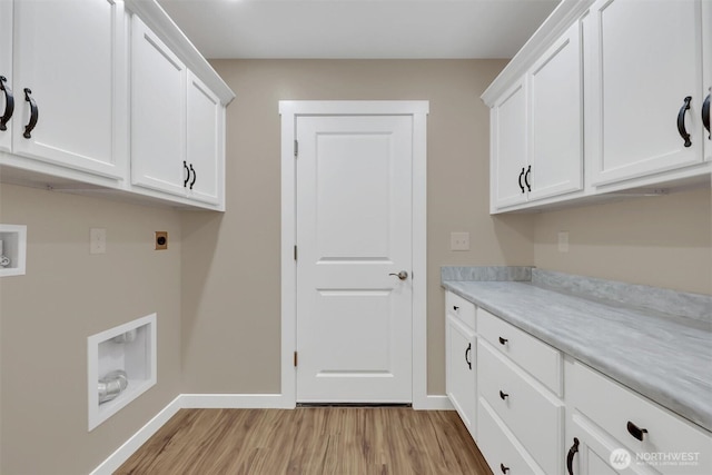 clothes washing area featuring baseboards, cabinet space, electric dryer hookup, and light wood finished floors