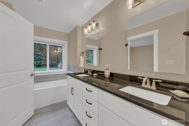 full bath with a garden tub, a sink, and double vanity