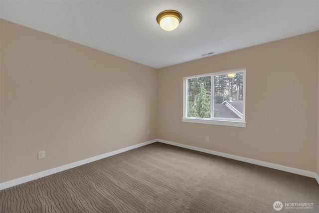 carpeted spare room with visible vents and baseboards