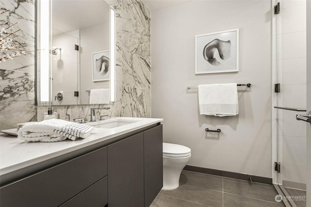 bathroom with tile patterned floors, toilet, a shower with door, and vanity