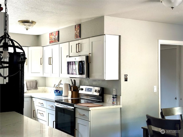 kitchen with white cabinets, a textured ceiling, and appliances with stainless steel finishes