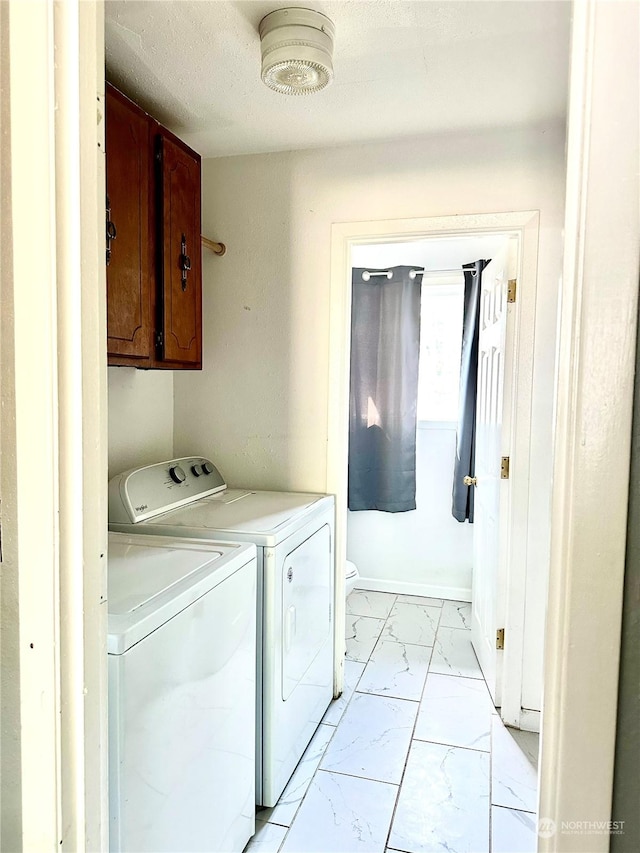 clothes washing area featuring washing machine and clothes dryer and cabinets