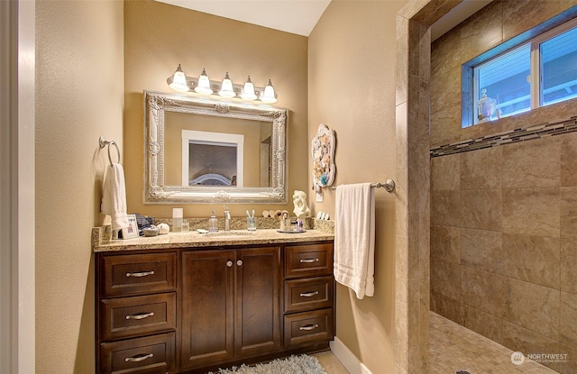 bathroom with vanity and a tile shower