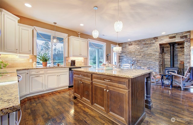 kitchen featuring a kitchen island, dark hardwood / wood-style floors, dishwasher, decorative backsplash, and hanging light fixtures