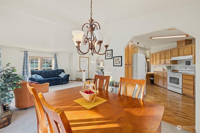 dining space with a chandelier and vaulted ceiling with beams