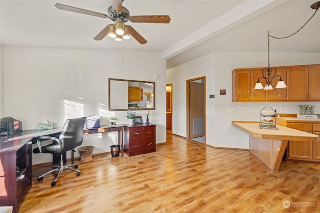 home office with light hardwood / wood-style floors and ceiling fan with notable chandelier