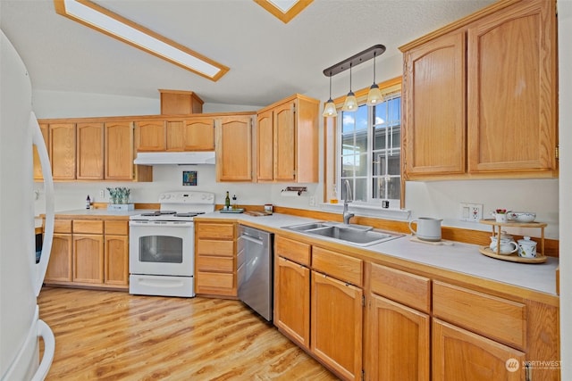 kitchen with pendant lighting, sink, white appliances, light hardwood / wood-style floors, and lofted ceiling